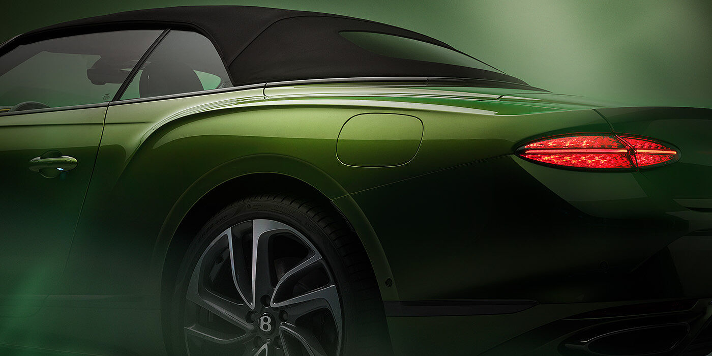 Bentley Hampshire Bentley New Continental GTC Speed rear haunch and tail lamp in Tourmaline Green paint and dark tint brightware with black hood up and illuminated head lamps